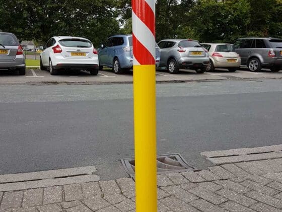 Removable steel security bollard in an urban setting, providing temporary vehicle restriction.